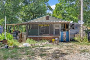 Front exterior view of a rustic 1-bedroom lake cabin for sale near Lake Texoma at 369 Dogwood Ln, Mead, OK.